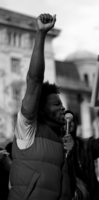 A Black man holds up a fist in a crowd