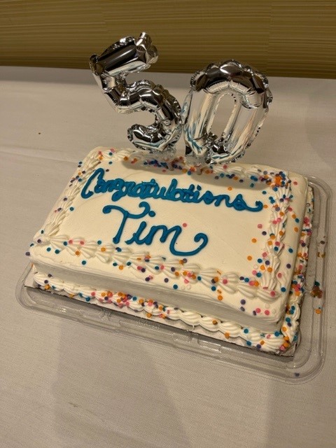 a cake which reads, “Congratulations Tim”