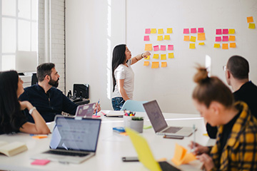 Woman placing sticky notes on wall