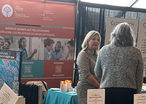 Co-Director Catherine Gilbert chats with an attendee at the JLP kiosk 