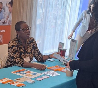 A woman sitting at a table speaks to a participant