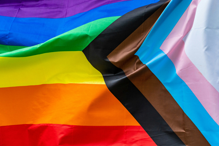 The progressive Pride flag waves in the wind