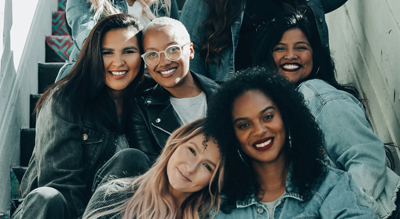 Des femmes de diff&eacute;rentes origines culturelles, assises sur un escalier dans une atmosph&egrave;re chaleureuse. 