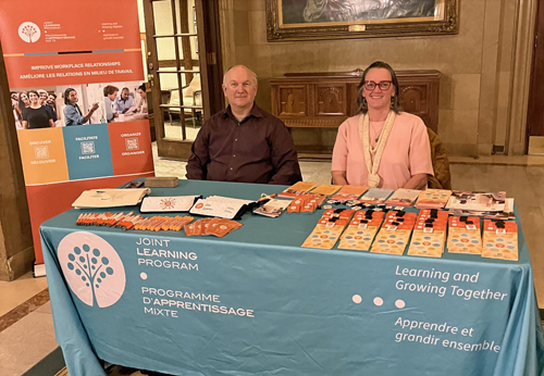 Ronald and Michele smile at the JLP kiosk